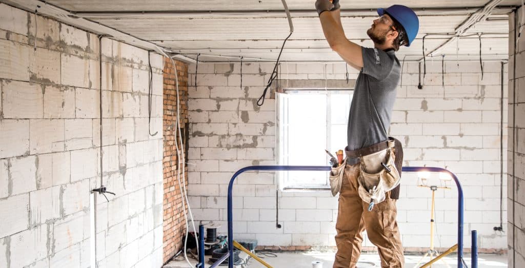 Un employé de Bélisle Construction au travail après la démolition d'un sous-sol résidentiel inondé à cause de fortes pluies dans les régions de Montréal et Lanaudière